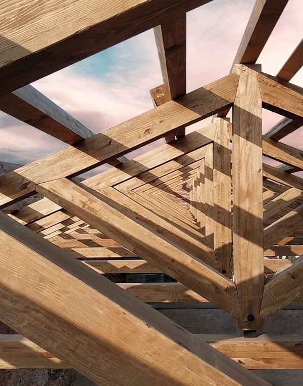 Visualización de la estructura de madera triangular de un pórtico de madera. Diseño elegante y funcional que resalta la belleza y la resistencia de la madera en la arquitectura. La estructura triangular ofrece soporte sólido y un aspecto estético atractivo para el espacio exterior.