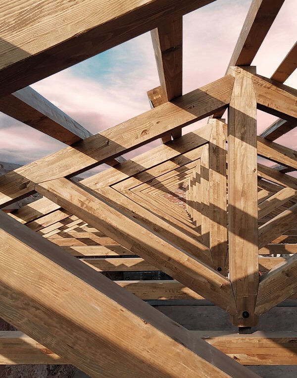 Visualización de la estructura de madera triangular de un pórtico de madera. Diseño elegante y funcional que resalta la belleza y la resistencia de la madera en la arquitectura. La estructura triangular ofrece soporte sólido y un aspecto estético atractivo para el espacio exterior.